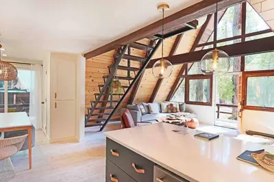 a kitchen and living room with a spiral staircase at Mid Century Modern Cabin - The Tahoe A-Frame in Homewood