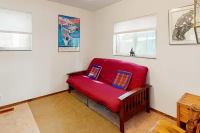 a red couch in a room with two pillows on it at Zen Amongst the Trees in Truckee