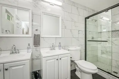 a white bathroom with a toilet and a glass shower at Fun City Haven Spacious Retreat in Fresno in Fresno