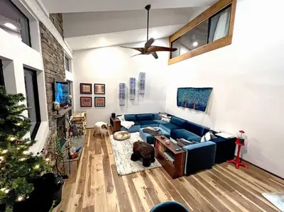 a living room with a blue couch and a christmas tree at Gondola Chalet -New Luxury 5 Bdrm Condo @ Canyon Lodge, Steam Room in Mammoth Lakes