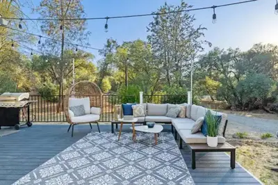 a patio with a couch and chairs and a table at Brookside Cottage in Mariposa
