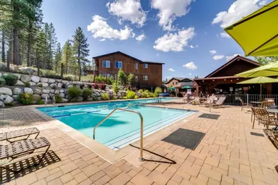 a swimming pool with patio furniture and a building at Boulders Truckee Condo Near Donner Lake and Skiing! in Truckee