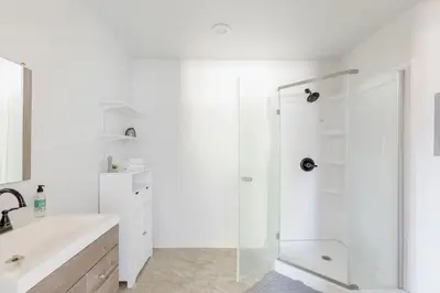 a white bathroom with a shower and a sink at Beautiful spacious guest home in Roseville