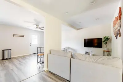 a living room with a white couch and a flat screen tv at Beautiful spacious guest home in Roseville