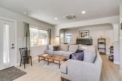 a living room with a couch and a table at MidTown Reno Vacation Rental with Fenced-In Yard! in Reno