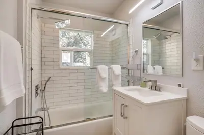 a white bathroom with a sink and a shower at MidTown Reno Vacation Rental with Fenced-In Yard! in Reno