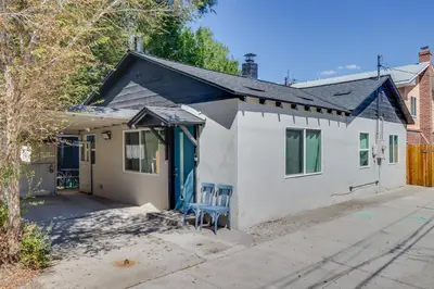 a white house with a blue door at MidTown Reno Vacation Rental with Fenced-In Yard! in Reno