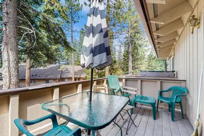 a table and chairs on a porch with an umbrella at Mountain Shadows in Incline Village