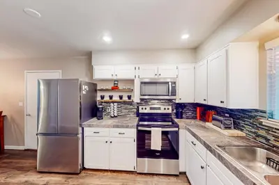 a kitchen with white cabinets and a stainless steel refrigerator at Jordan Oak in Groveland