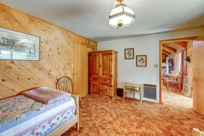 a bedroom with a bed and a wooden wall at Countryside Views Family-Friendly Badger Cabin in Badger