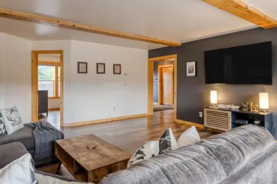 a living room with a couch and a flat screen tv at The Modern Moose Lodge in Truckee