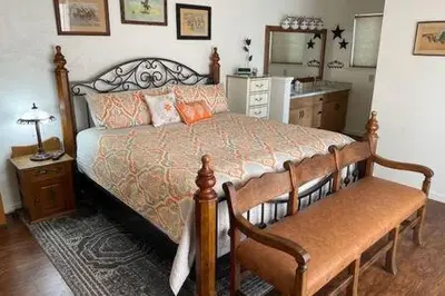 a bedroom with a bed and a table and a mirror at Creekside Suite Sleeps 2 Creek frontage Bbq in Oakhurst