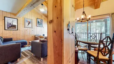 a living room with wooden walls and a dining room at Chamonix #64 condo in Mammoth Lakes