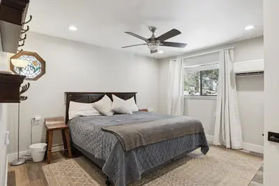 a bedroom with a bed and a ceiling fan at Spacious Pine Mountain Lake Cabin Rental with Decks in Groveland