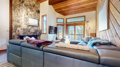 a large leather couch in a room with a stone wall at Snowcreek III #452 condo in Mammoth Lakes
