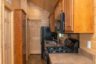 a kitchen with a stove and a sink at Jellystone Park Tower Park Resort in Lodi