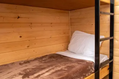 a room with a bunk bed in a wooden cabin at Jellystone Park Tower Park Resort in Lodi