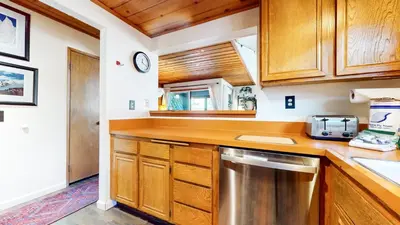 a kitchen with wooden cabinets and a stainless steel dishwasher at Courchevel #5 condo in Mammoth Lakes