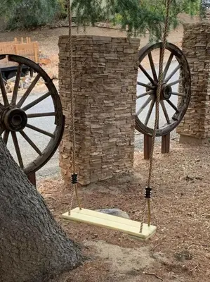 a woodenokedoked wheel sitting next to a tree at Tillie Creek Retreat: a Creekside Oasis in Wofford Heights