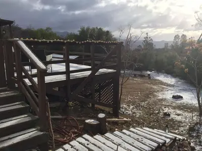 a bridge over a river next to a river at Shirley Creek Retreat: a Mountain Oasis in Wofford Heights