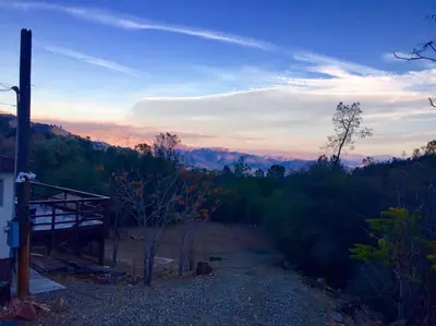 a view of a forest with a sunset in the background at Shirley Creek Retreat: a Mountain Oasis in Wofford Heights