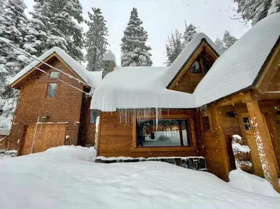 a house covered in snow with icicles hanging from it at FamilyfunCabin in Tahoma