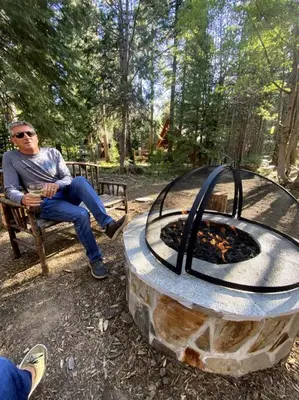 a man sitting on a bench next to a fire pit at FamilyfunCabin in Tahoma