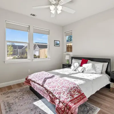 a bedroom with a bed and two windows at Newly Built Murphys Modern Retreat in Murphys