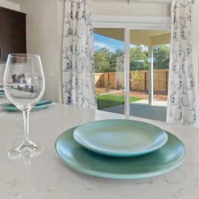 a table with a glass of wine and a plate at Newly Built Murphys Modern Retreat in Murphys
