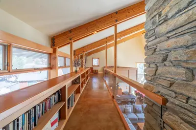 a large stone wall in a library with bookshelves at Rr-carson_view1 Strap18-005 in June Lake