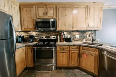 a kitchen with wooden cabinets and stainless steel appliances at BEST Location . Walk To Canyon Lodge . Views . Pool/Spa in Mammoth Lakes