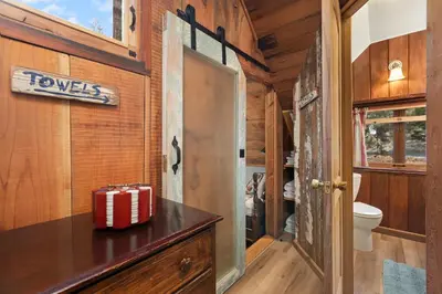 a small bathroom with a toilet and a door at The Knotty Cabin in Kings Canyon National Park in Wilsonia
