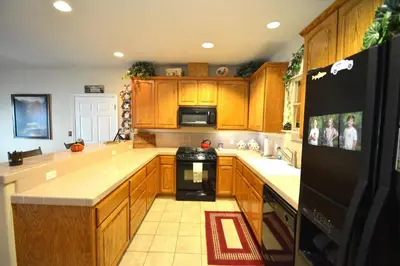 a kitchen with wooden cabinets and a black refrigerator at Forward-Lake Area in Bass Lake