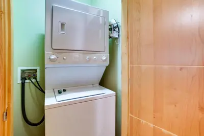 a washer and dryer in a bathroom with a door at Mammoth Lakes Condo with Fireplace Near Skiing! in Mammoth Lakes