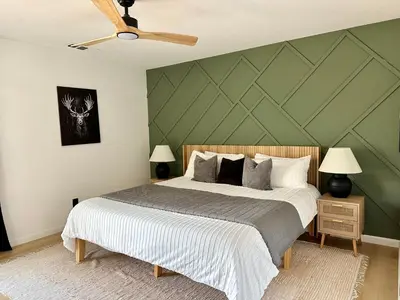 a bedroom with a large bed with a green wall at Prime location Yosemite Adventure by Casa Oso in Oakhurst