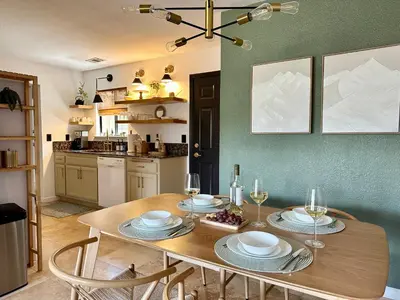 a dining room table with plates and wine glasses at Prime location Yosemite Adventure by Casa Oso in Oakhurst