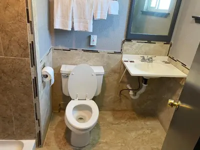 a bathroom with a toilet and a sink at Valley Motel in Atwater