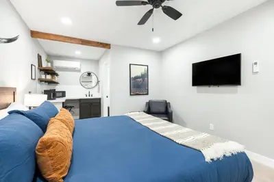 a bedroom with a blue bed and a flat screen tv at The Moro | Sequoia Motel RM3 in Three Rivers