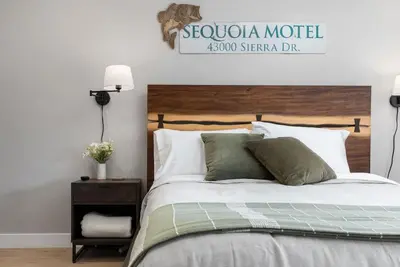 a bedroom with a large bed with a wooden headboard at The Belle Sequoia Motel RM9 in Three Rivers