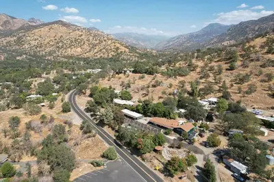 an aerial view of a town with a road and mountains at The Belle Sequoia Motel RM9 in Three Rivers