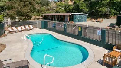 an empty swimming pool with chairs and a fence at The Tokopah Sequoia Motel RM 1 in Three Rivers