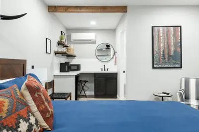 a bedroom with a blue bed and a fireplace at The Rae | Sequoia Motel RM 5 in Three Rivers