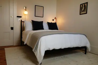 a bedroom with a large white bed with black pillows at Imperial Hotel + Restaurant in Amador City