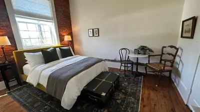 a bedroom with a bed and a table and chairs at Imperial Hotel + Restaurant in Amador City