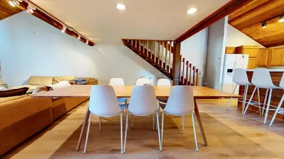 a dining room with a wooden table and white chairs at Snowcreek I #52 condo in Mammoth Lakes