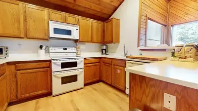 a kitchen with wooden cabinets and a white stove top oven at Snowcreek I #52 condo in Mammoth Lakes