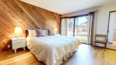a bedroom with a large bed with a wooden wall at Snowcreek I #52 condo in Mammoth Lakes