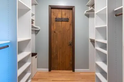 a closet with a wooden door in a room at Cedar Ridge Hot Tub BBQ Sleeps 8 in Oakhurst