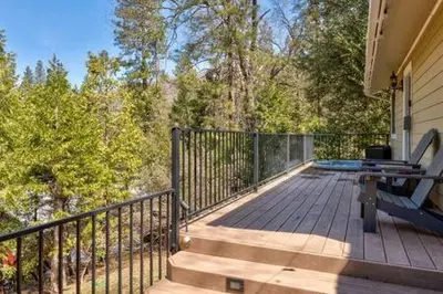 a deck with a bench and a grill on a house at Cedar Ridge Hot Tub BBQ Sleeps 8 in Oakhurst