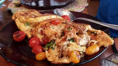 a plate of food with a pie and tomatoes at Yosemite Plaisance Bed & Breakfast in Mariposa